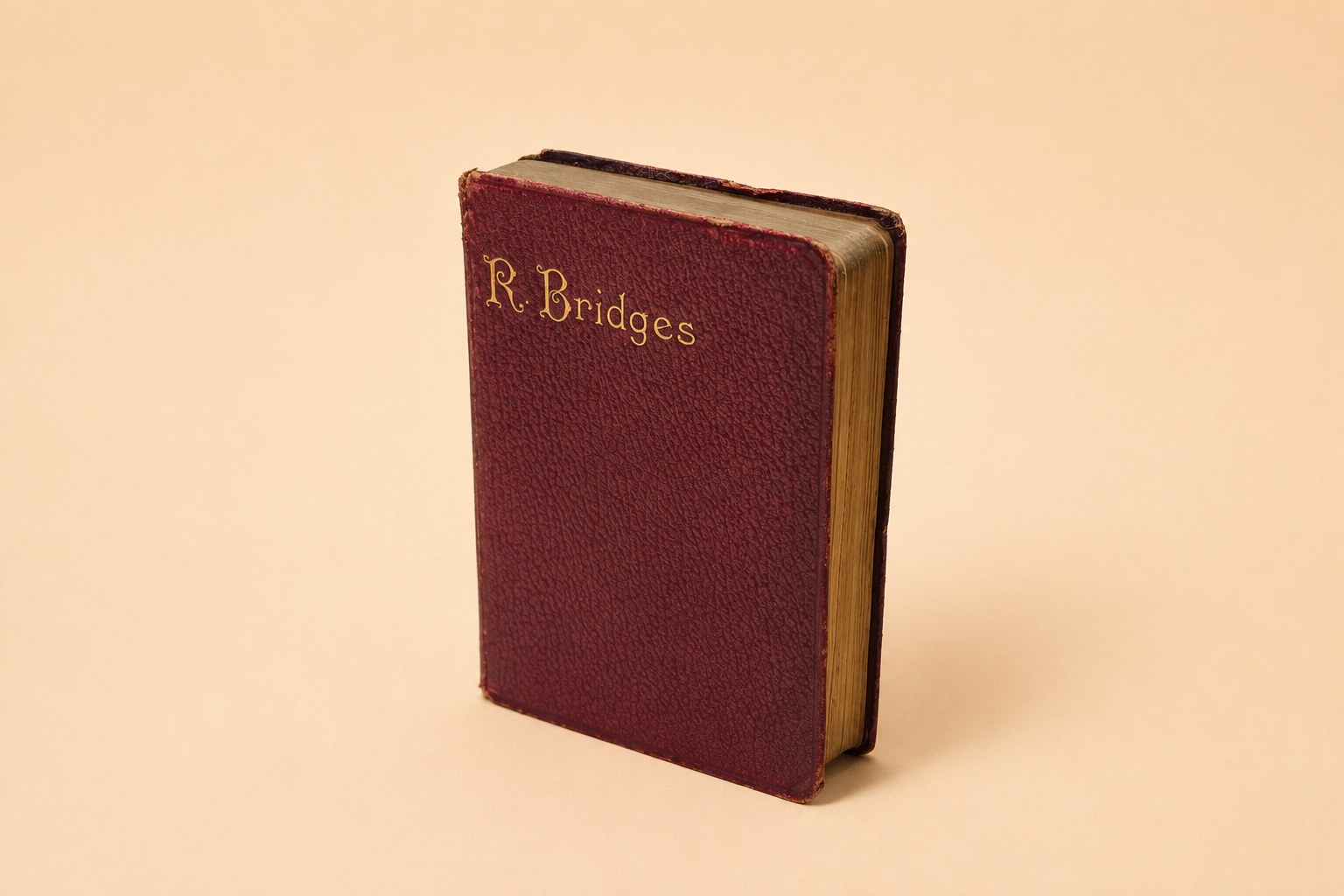 A 1914 Oxford Edition of the Poetical Works of Robert Bridges: maroon pocket volume with gilt page-edges, open to a marbled flyleaf inscribed in ink 'To Dear Alice, With fondest love, Xmas 1920', with its photogravure frontispiece portrait of the bearded poet and two old newspaper clippings from John o' London's Weekly laid in.